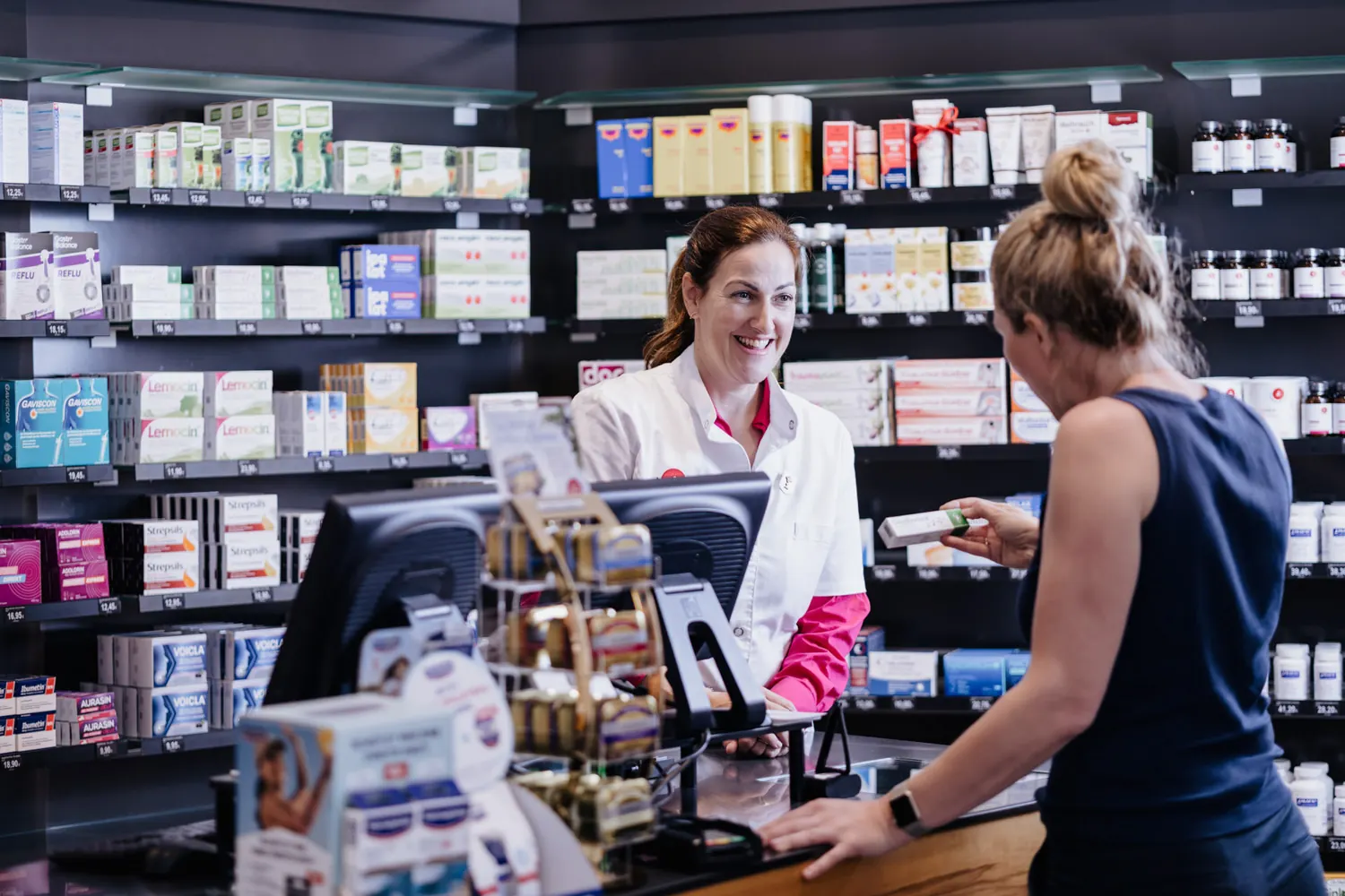 Mitarbeiterin der Zentral-Apotheke bedient eine Kundin an der Kassa