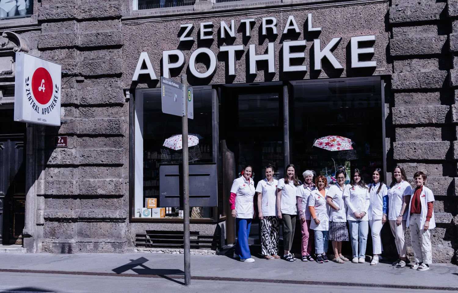 Fassade der Zentral-Apotheke in der Innsbrucker Anichstraße mit Schriftzug „Zentral Apotheke“ und dem Team davor