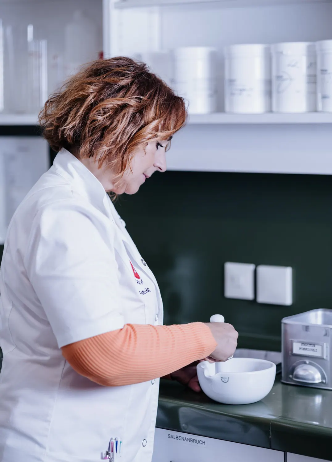 Apothekerin arbeitet im Labor mit Mörser und Pistill