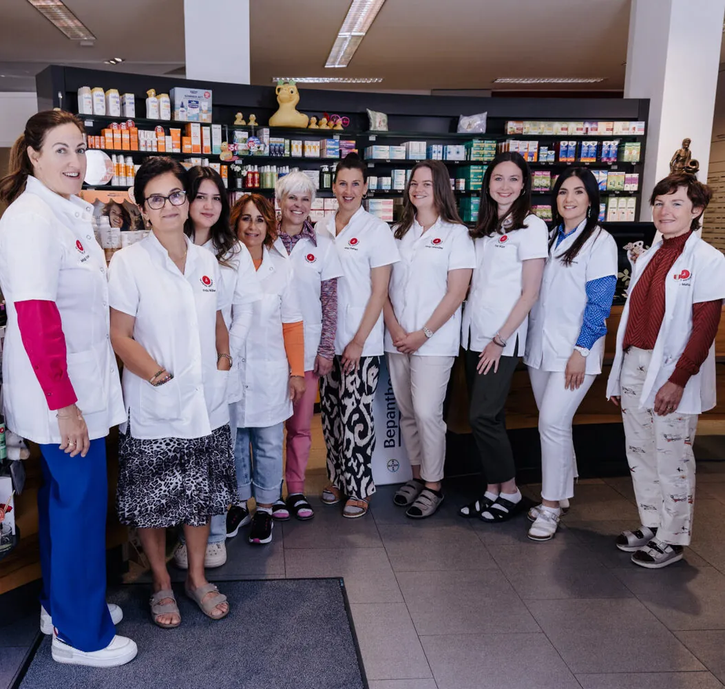 Gruppenfoto des Teams der Zentral-Apotheke in weißen Kitteln in der Offizin